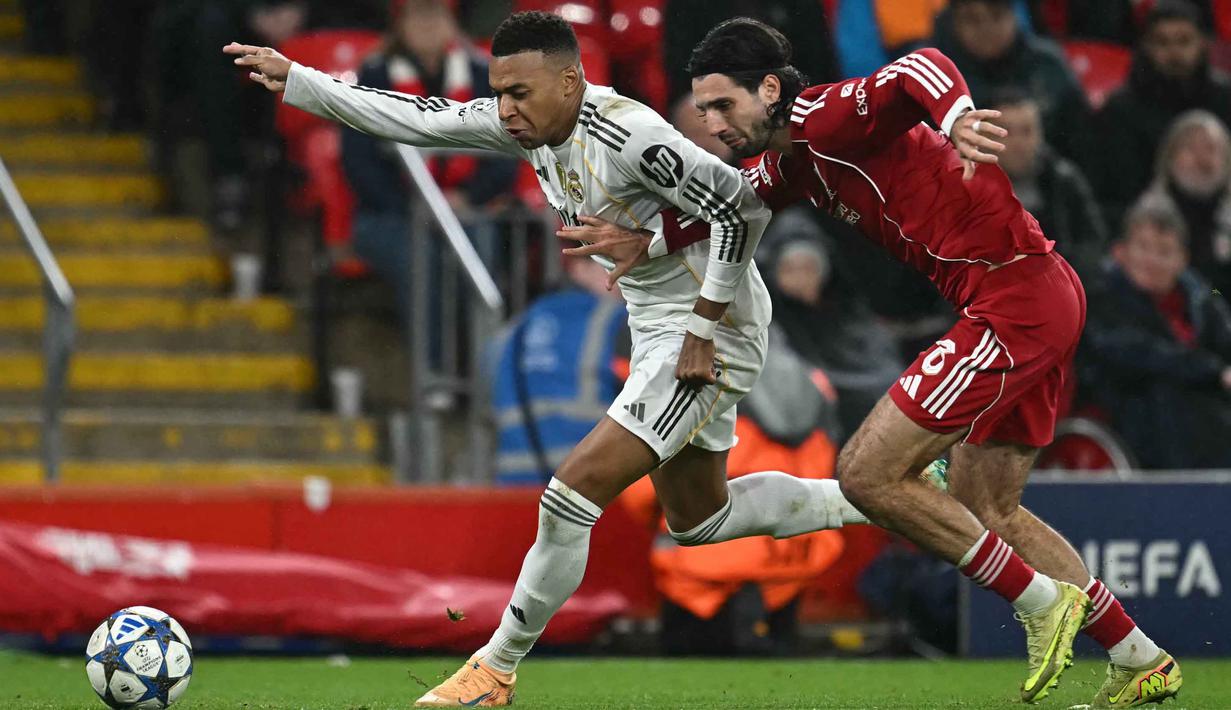 Penyerang Real Madrid asal Prancis, Kylian Mbappe (kiri) berebut bola dengan gelandang Liverpool asal Hungaria, Dominik Szoboszlai dalam pertandingan pekan keempat Liga Champions 2025-2026 di Stadion Anfield, Inggris, pada Selasa 4 November 2025 waktu setempat atau Rabu (5/11/2025) dini hari WIB. Berlaga di markas sendiri, The Reds tampil penuh percaya diri sejak menit awal pertandingan. (Paul ELLIS/AFP)