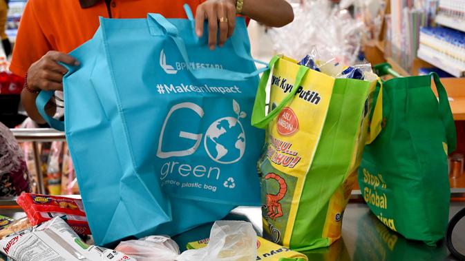 Karyawan mengemas barang belanjaan konsumen dengan tas belanja nonplastik di sebuah supermarket di Denpasar, 16 Juli 2019. Bali menerapkan pelarangan penggunaan plastik sekali pakai yang tertuang dalam Peraturan Gubernur (Pergub) Nomor 97 Tahun 2018. (SONNY TUMBELAKA/AFP)