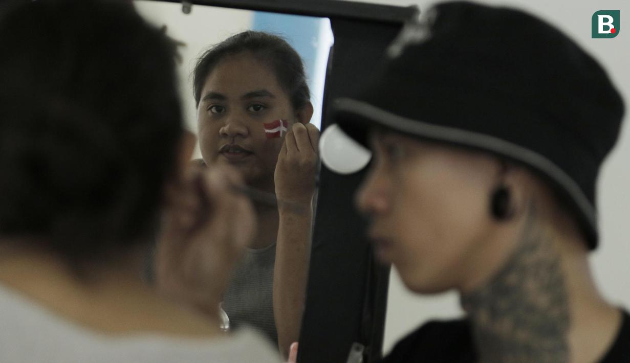 Fans Indonesia mengambar bendera di wajahnya saat Blilbli Indonesia Open 2018 di Istora Senayan, Jakarta, Kamis, (5/7/2018). Indonesia memborong dua gelar melalui Kevin/Marcus dan Tontowi Ahmad/Liliyana Natsir. (Bola.com/M Iqbal Ichsan)