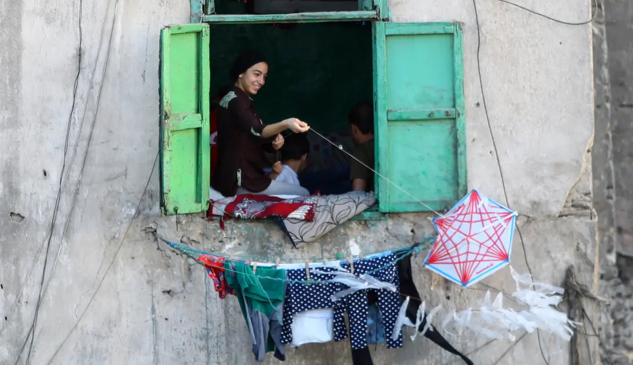 Seorang perempuan menerbangkan layang-layang dari rumah selama masa pandemi COVID-19 di Kairo, Mesir, pada Senin (11/5/2020). Mesir mencatatkan peningkatan harian sebanyak 346 kasus infeksi COVID-19, menambah jumlah kasus terkonfirmasi di negara itu menjadi 9.746. (Xinhua/Ahmed Gomaa)
