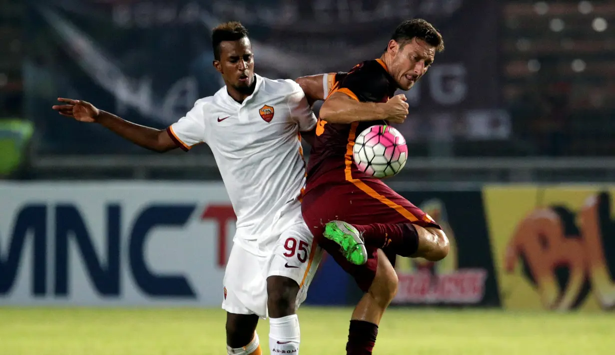 Francesco Totti (kanan) berebut bola dengan Elio Capradossi. (EPA/Mast Irham)