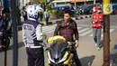 Petugas Dishub melakukan sosialisasi penggunaan masker kepada pengendara motor di kawasan Depok, Jawa Barat, Senin (20/7/2020). Pemkot Depok melalui Gugus Tugas Percepatan Penanganan COVID-19 turun ke jalan tiga hari ke depan untuk menggencarkan Gerakan Bermasker. (Liputan6.com/Immanuel Antonius)