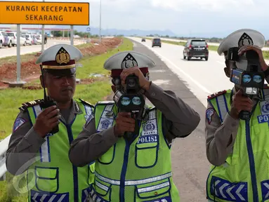 Polisi gunakan alat pendeteksi laju kendaraan di ruas tol Cikampek-Palimanan KM.165, Majalengka, (14/12). Polda Jabar bekerjasama dengan PT Lintas Marga Sedaya (LMS) melakukan berbagai langkah penegakan hukum. (Liputan6.com/Angga Yuniar)