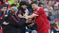 Manajer Liverpool Legends, Jurgen Klopp (kiri), berjabat tangan dengan gelandang Liverpool Legends, Steven Gerrard (kanan), saat ia diganti selama pertandingan Legends antara Liverpool Legends dan Dortmund Legends di Anfield, Liverpool, Inggris barat laut pada 28 Maret 2026.
(PETER POWELL/AFP)