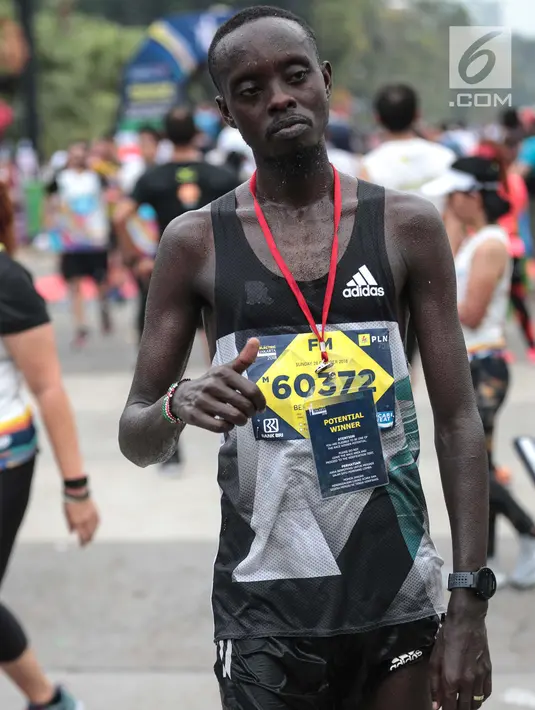 Pelari kenya Bernard Mwendia Muthoni usai menyelesaikan lari Full Marathon dalam Jakarta Marathon 2018 di GBK, Jakarta, Minggu (28/10). Bernard berhasil sampai finish kategori Full Marathon dalam catatan waktu 02:19:10. (Liputan6.com/Faizal Fanani)