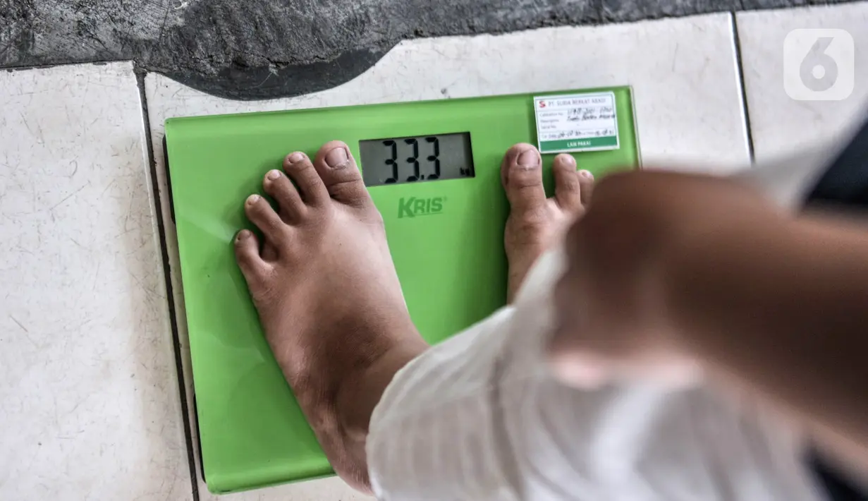 Seorang anak menimbang berat badan sebelum mengikuti program BIAS di Kantor Kelurahan Tamansari, Jakarta, Selasa (24/11/2020). BIAS dipusatkan di kantor kelurahan masing-masing wilayah. (merdeka.com/Iqbal S. Nugroho)