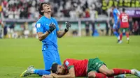 Kiper Timnas Maroko, Yassine Bounou dan rekannya, Achraf Hakimi merayakan kemenangan atas Timnas Portugal usai berakhirnya laga babak perempatfinal Piala Dunia 2022 di Al Thumama Stadium, Doha, Qatar, Sabtu (10/12/2022) malam WIB. (AP/Ariel Schalit)
