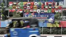 Bajaj melintas di depan instalasi berupa bendera negara-negara peserta Asian Games 2018 di Jalan Tanah Tinggi Barat, Kelurahan Bungur, Kecamatan Senen, Jakarta, Minggu (15/7). (Merdeka.com/Iqbal S. Nugroho)