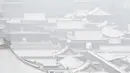 Pengunjung saat mengunjungi taman di dekat Kota Terlarang setelah salju turun di Beijing (30/11/2019). Salju pertama di Beijing musim dingin ini paling tepat waktu. menurut para ahli hujan salju yang banyak tertunda pada musim dingin tahun lalu yang kekeringan. (AFP Photo/Wang Zhao)