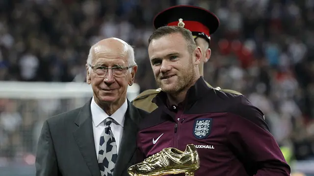 SEPATU EMAS - Wayne Rooney menerima penghargaan sepatu emas yang diserahkan langsung oleh Sir Bobby Charlton, Sabtu (10/10/2015) dini hari WIB. (AFP/IAN KINGTON).