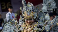 Senyum seorang peserta saat mengenakan kostum adat Indonesia saat berpartisipasi dalam parade Jember Fashion Carnaval 2017 di pulau Jawa timur (13/8). Sekitar 2000 peserta mengelilingi rute 3,6 kilometer di sekitar kota. (AFP Photo/Juni Kriswanto)