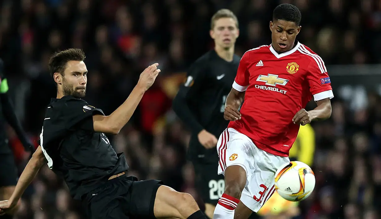 Striker Manchester United, Marcus Rashford, berusaha melewati pemain Midtjylland, Tim Sparv. Louise Van Gaal memainkan Rashford karena striker utama mereka Anthony Martial cedera. (EPA/Nigel Roddis)