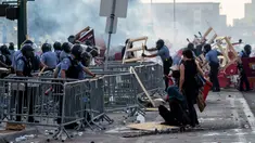 Polisi menyingkirkan barikade yang dibuat demonstran saat unjuk rasa atas kematian George Floyd oleh polisi di luar Third Police Precinct, Minneapolis, Minnesota, Amerika Serikat, Rabu (27/5/2020). Kematian George Floyd memicu kerusuhan di Minneapolis. (Kerem Yucel/AFP)