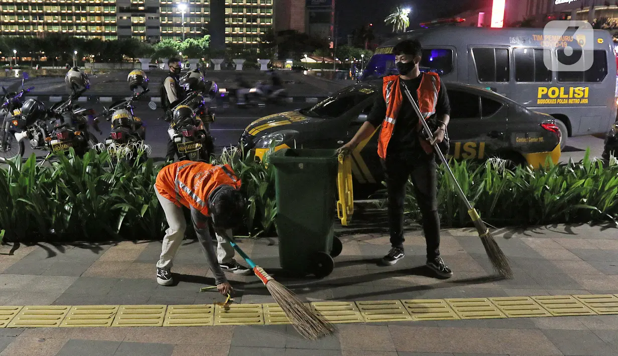 Sejumlah orang diberikan sanski menyapu setelah terjaring pada patroli penegakan protokol kesehatan COVID-19 di pos polisi Bundaran HI, Jakarta, Sabtu (26/12/2020). Operasi gabungan itu dilakukan menyusul meningkatnya penyebaran COVID-19 di Ibu kota. (Liputan6.com/Herman Zakharia)