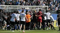 Beberapa suporter Bastia masuk ke lapangan dan menyerang para pemain Olympique Lyon yang membuat laga di Stade Armand Cesari tertunda, Minggu (16/4/2017). (AFP/Pascal Pochard-Casabianca)