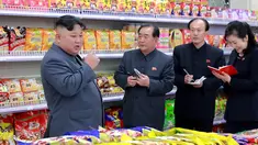Pemimpin Korea Utara, Kim Jong-un berbincang dengan stafnya ketika berada di toko makanan saat mengunjungi Taesong Department Store setelah dibuka untuk umum di Korea Utara (8/4). (KCNA VIA AFP Photo)