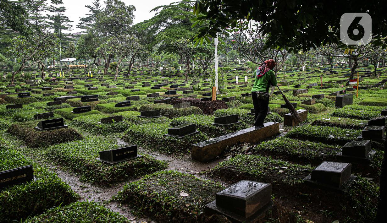 Petugas kebersihan menyapu area makam di Tempat Pemakaman Umum (TPU) Karet Bivak, Jakarta, Minggu (27/6/2021). Pemerintah Provinsi DKI Jakarta membatasi aktivitas dan kunjungan ke TPU hingga 5 Juli 2021 untuk menekan penularan COVID-19. (Liputan6.com/Faizal Fanani)