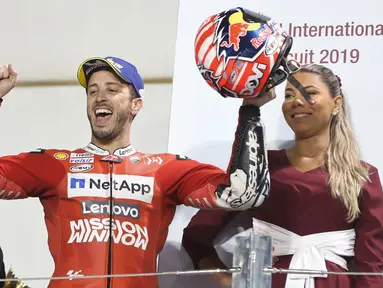 Pembalap Ducati, Andrea Dovizioso berselebrasi usai berhasil memenangkan seri pembuka MotoGP di Sirkuit Internasional Losail di Doha, Qatar (10/3). Dovizioso berhasil mengalahkan Marc Marquez dengan selisih waktu 0,023 detik. (AP Photo/Hanson Joseph)