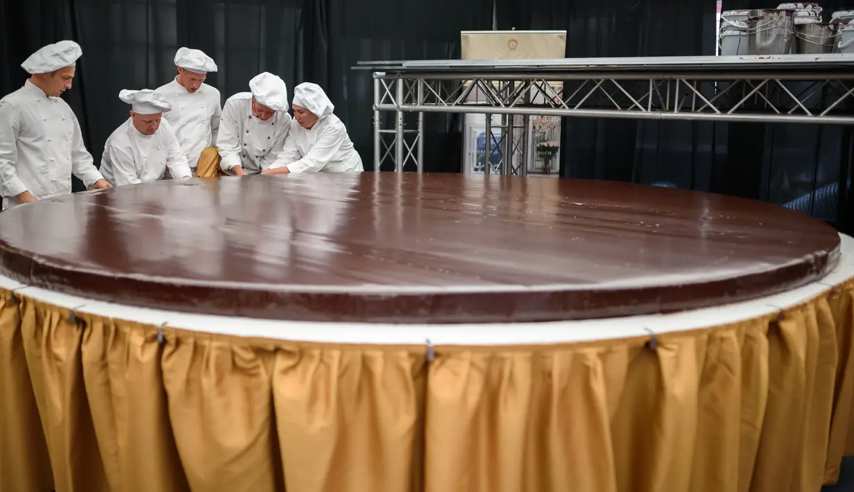 Sejumlah koki menyelesaikan pembuatan kue cokelat atau dikenal sebagai Sacher Torte di Ljubljana, Slovenia, Rabu (21/9). Kue cokelat dengan diameter 3,5 meter ini menghabiskan 2.000 butir telur, 80 kg selai, dan 200 kg cokelat. (AFP PHOTO/Jure MAKOVEC)