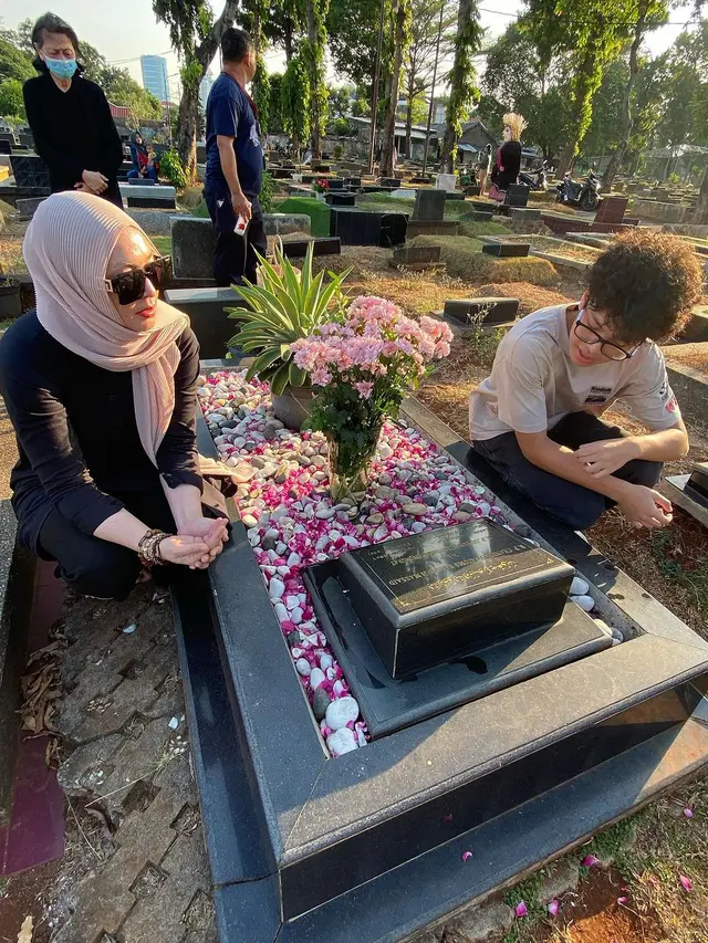 Angelina Sondakh dan anaknya di makam Adjie Massaid (Instagram/angelinasondakh09)