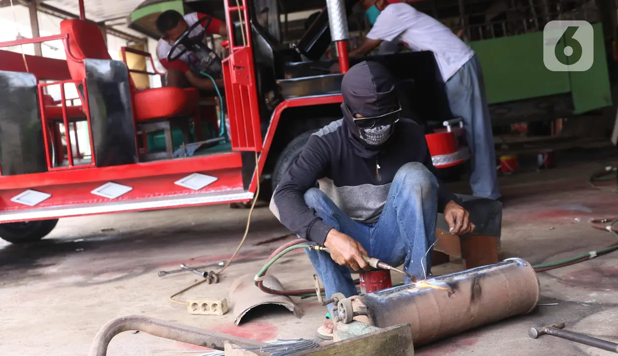 Pekerja melakukan pengelasan saat pembuatan mobil wisata Odong-Odong di bengkel perakitan milik Didik Hermawan di Jurangmangu, Tangerang Selatan, Sabtu (27/2/2021). Dalam sebulan, bengkel tersebut bisa menjual empat hingga lima unit odong-odong. (Liputan6.com/Angga Yuniar)