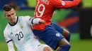 Pemain Argentina, Giovani Lo Celso berebut bola dengan pemain Chile, Junior Fernandes selama bertanding pada perebutan tempat ketiga Copa America 2019 di Arena Corinthians, Brasil (6/7/2019). Argentina sukses  merebut posisi ketiga usai mengalahkan Chile 2-1. (AP Photo/Andre Penner)