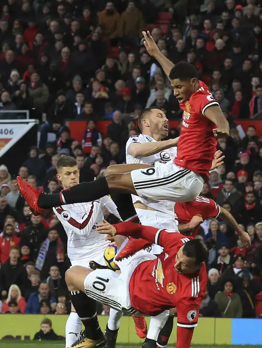 Pemain Manchester United, Marcus Rashford (atas) dan Zlatan Ibrahimovic (bawah) berebut bola dengan pemain Burnley  pada lanjutan Premier League di Old Trafford,  Manchester (26/12/2017).  MU bermain imbang 2-2. (AFP/Lindsey Parnaby)