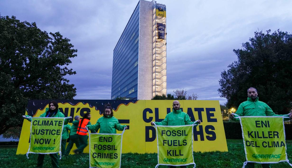 Aktivis organisasi lingkungan Greenpeace membuka spanduk di samping gedung kantor pusat ENI—perusahaan minyak dan gas Italia—di Roma, Italia, Selasa, 5 Desember 2023. (AP Photo/Andrew Medichini)