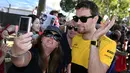 Seorang penggemar melakukan selfie dengan pembalap tim Renault, Jolyon Palmer, menjelang sesi latihan bebas pertama di Grand Prix Australia, Melbourne, Jumat (24/3). (AFP Photo/WILLIAM WEST)