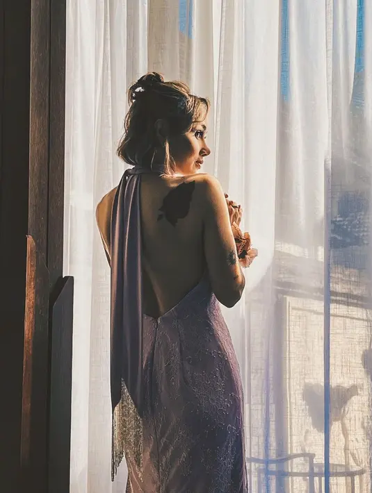 Desain backless dress tampilkan tato mawar merah di punggung [@sarawijayanto]