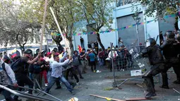 Para demonstran bentrok dengan polisi saat unjuk rasa di Quito, Ekuador, Kamis (13/8/2015). Para pendemo mengecam pemerintah untuk menghormati konstitusi.  (REUTERS/Guillermo Granja)