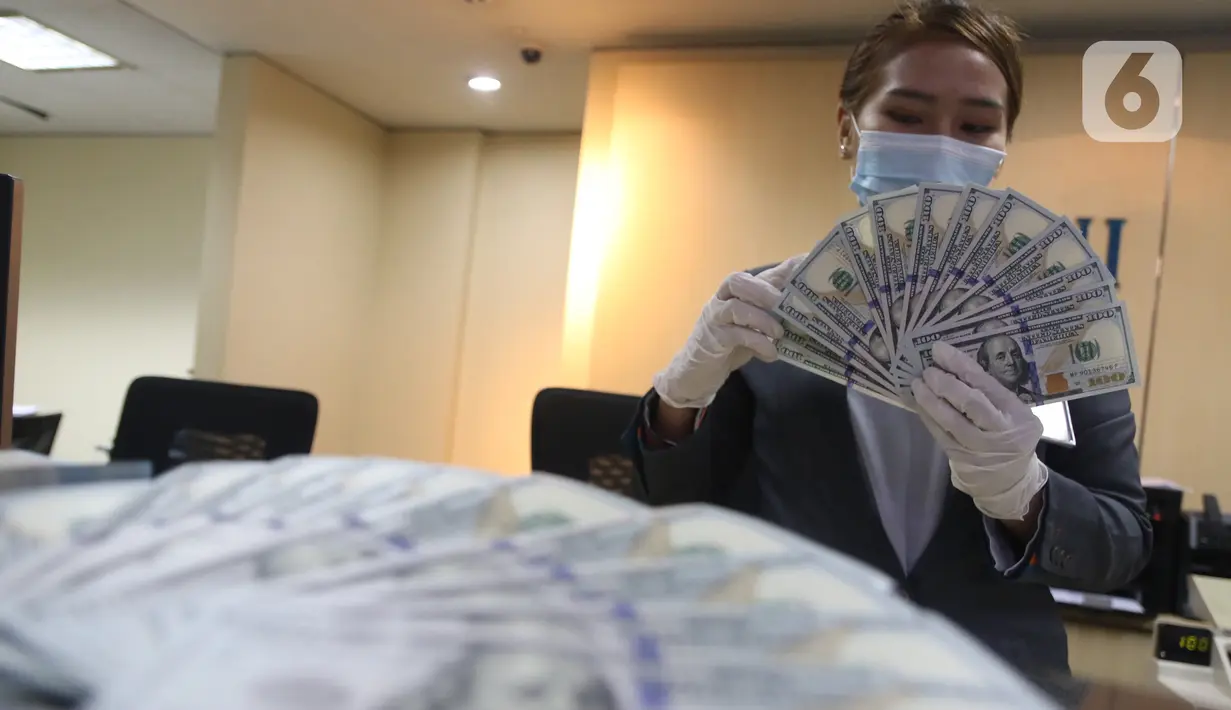Karyawan bank menunjukkan mata uang dolar Amerika Serikat (AS) di Jakarta, Senin (2/11/2020). Nilai tukar rupiah pada perdagangan Senin (2/11) sore ditutup melemah 0,1 persen ke level Rp14.640 per dolar AS, dari perdagangan sebelumnya yaitu Rp14.690 per dolar AS. (Liputan6.com/Angga Yuniar)