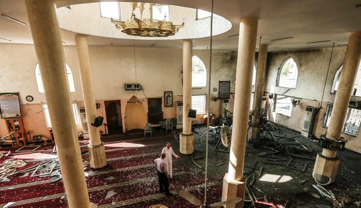 Dua pria memeriksa kerusakan masjid yang terkena serangan udara Israel di Kota Gaza, Palestina (15/7). Militer Israel mengatakan telah meluncurkan serangan udara yang menargetkan pasukan Hamas di Jalur Gaza, Sabtu (14/7) lalu. (AFP  Photo/Mahmud Hams)