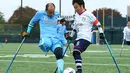 Pemain FC Kyushu Shintaro Kaminaka (kiri) berebut bola dengan pemain FC Alvorada Yoshihiko Endo saat pertandingan final di Jepang. FC Kyushu Bairaor merupakan tim profesional pertama yang pemainnya memiliki cacat fisik. (Aflo/Rex Shutterstock/Dailymail)