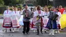 Warga Belarusia dengan kostum nasional berjalan ke Sungai Berezina pada Hari Ivan Kupala di Desa Parichi, sekitar 200 km (125 mil) selatan Minsk, Belarusia, 6 Juli 2022. Ivan Kupala atau Hari St. John atau Hari Pertengahan Musim Panas adalah karnaval tradisional yang berpusat di sekitar api unggun dengan banyak makanan dan tarian. (AP Photo/Viktor Drachev)