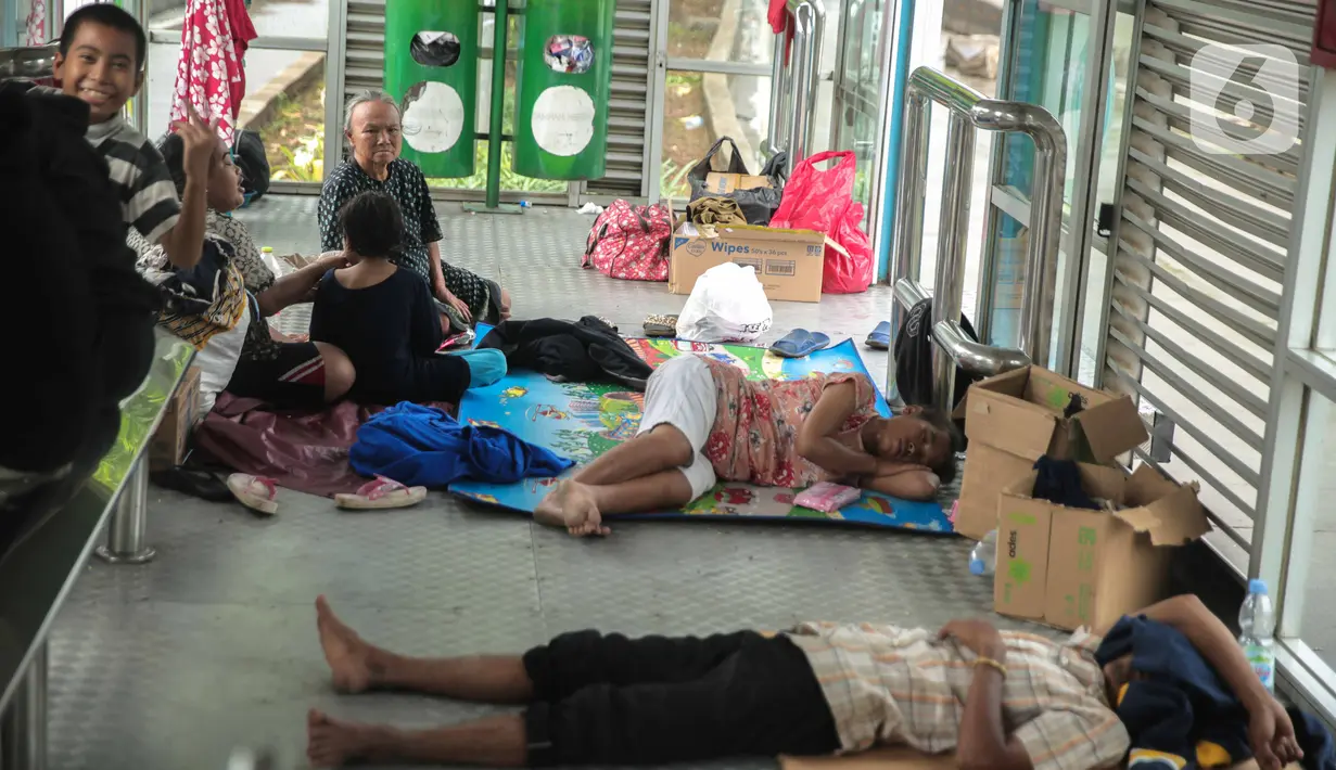 Korban banjir mengungsi di Halte Transjakarta Dispenda Samsat Barat, Jakarta Barat, Jumat (3/1/2020). Para korban terpaksa mengungsi ke halte tersebut akibat kurangnya posko pengungsian di sekitar lokasi terdampak banjir. (Liputan6.com/Faizal Fanani)