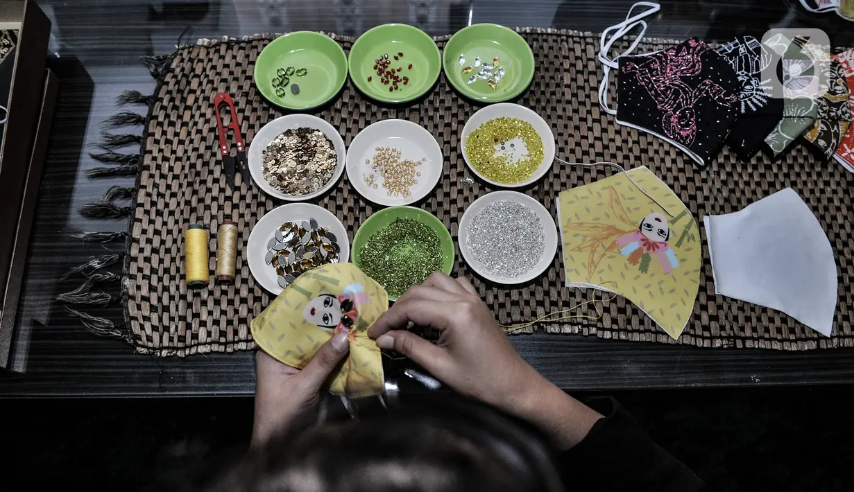Pekerja saat menyelesaikan pembuatan masker bercorak batik Betawi di Butik Elemwe, Jakarta, Selasa (22/12/2020). (merdeka.com/Iqbal S. Nugroho)