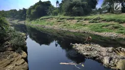 Warga mencari ikan di aliran Sungai Cileungsi yang berwarna hitam pekat di kawasan Bojong Kulur, Gunung Putri, Kabupaten Bogor, Jawa Barat, Selasa (23/7/2019). Air Sungai Cileungsi diduga  tercemar limbah pabrik sehingga menyebabkan ikan mati dan menimbulkan bau tak sedap. (merdeka.com/Arie Basuki)