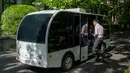 Seorang penumpang hendak menaiki minibus tanpa awak di Shanghai Jiao Tong University di Shanghai, China (8/5). Penumpang bisa memesan untuk menaiki bus ini dengan cara memindai kode melalui ponsel pintar mereka. (AFP Photo/China Out)