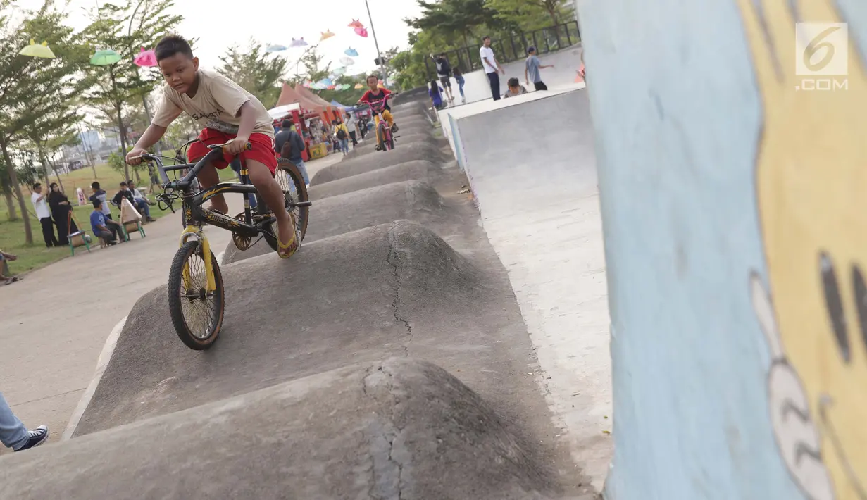 Seorang anak bermain sepeda di area Skate Park RPTRA Kalijodo, Jakarta, Sabtu (15/6/2019). Menjelang sore hari, anak-anak berdatangan menghabiskan waktu dengan bermain di area RPTRA Kalijodo. (Liputan6.com/Helmi Fithriansyah)