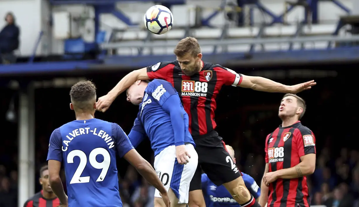 Striker Everton, Wayne Rooney, duel udara dengan bek Bournemouth, Simon Francis, pada laga Premier League, di Stadion Goodison Park, Sabtu (23/9/2017). Everton menang 2-1 atas Bournemouth. (AP/Barrington Coombs)