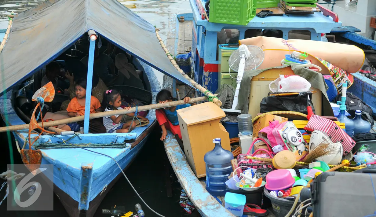 Sejumlah anak penghuni pasar ikan Penjaringan berada di atas perahu saat rumahnya mulai dihancurkan oleh alat berat petugas, Jakarta, Senin (11/4). Pemprov DKI membongkar ratusan rumah di wilayah Pasar Ikan. (Liputan6.com/Yoppy Renato)