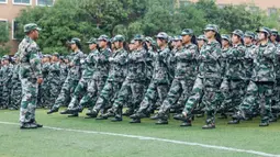 Murid sekolah menengah mengambil bagian dalam sesi pendidikan dan pelatihan militer pada awal semester baru di Huaibei, Provinsi Anhui, China, 5 September 2021. (STR/AFP)