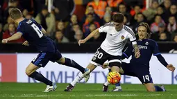 Gelandang Valencia, Rodrigo De Paul, berusaha melewati pemain Real Madrid, Luka Modric, pada laga La Liga Spanyol. Akibat hasil itu Madrid tertahan di posisi tiga klasemen sementara. (EPA/Juan Carlos Cardenas)