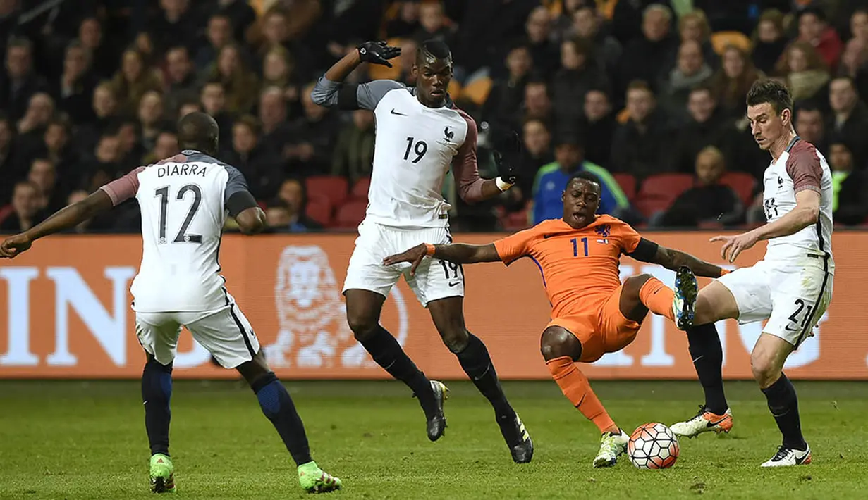 Gelandang Belanda, Quincy Promes, berusaha melepaskan diri dari kepungan pemain Prancis pada laga persahabatan di Stadion Amsterdam Arena, Amsterdam, Jumat (25/3/2016). Belanda takluk 2-3 dari Prancis. (AFP/John Thys)