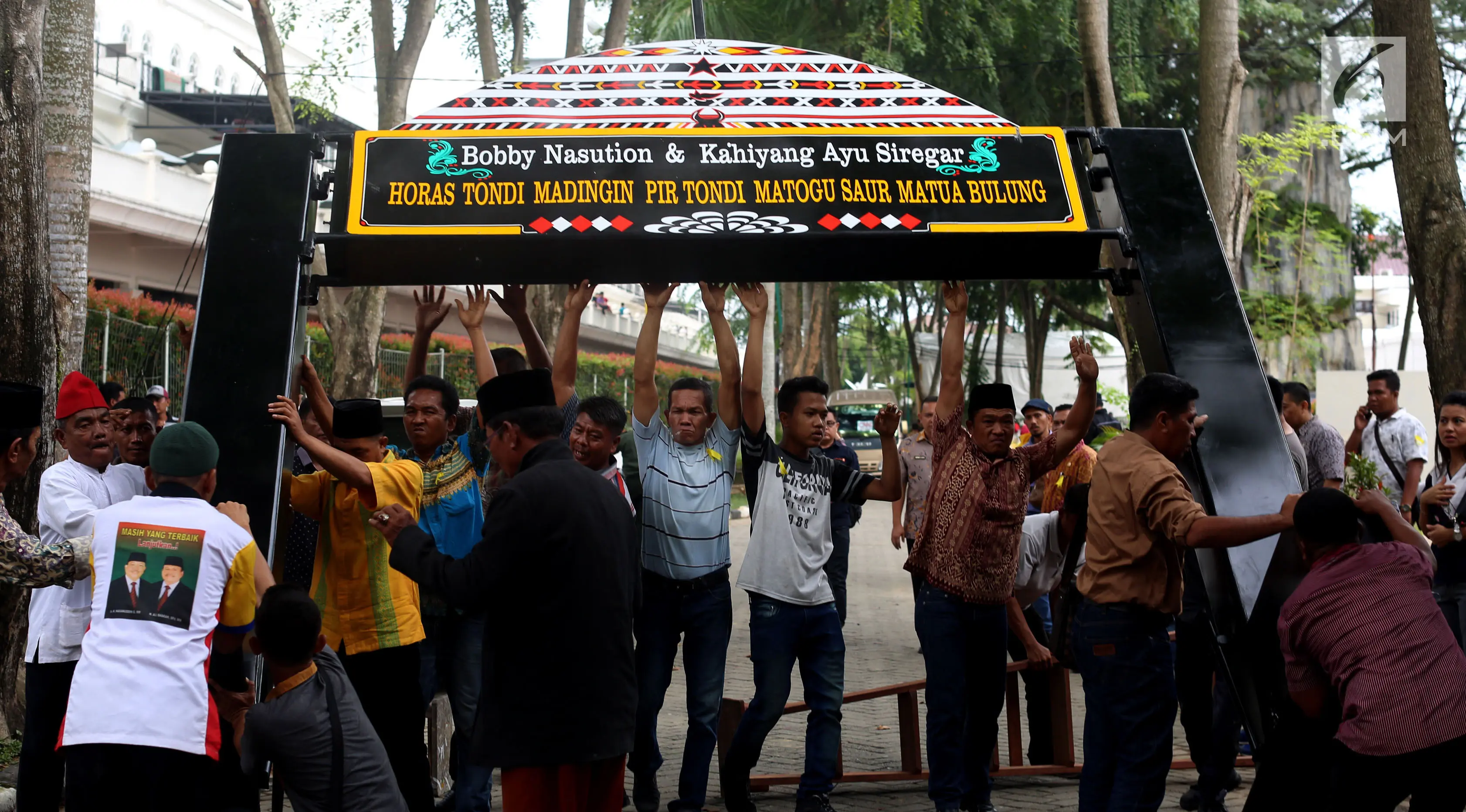 Pekerja memasang gapura menyambut tamu acara ngunduh mantu Kahiyang Ayu dan Bobby Nasution di Komplek Bukit Hijau Regency, Medan, Kamis (23/11). Rangkaian upacara adat dan resepsi Kahiyang dan Bobby dilangsungkan 24-26 November. (Liputan6.com/Johan Tallo)