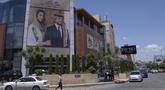 Sebuah poster bergambar Putra Mahkota Yordania Hussein dan tunangannya, arsitek Saudi Rajwa Alseif digantung di depan sebuah gedung di Amman, Yordania, Selasa, 30 Mei 2023. (AP Photo/Nasser Nasser)