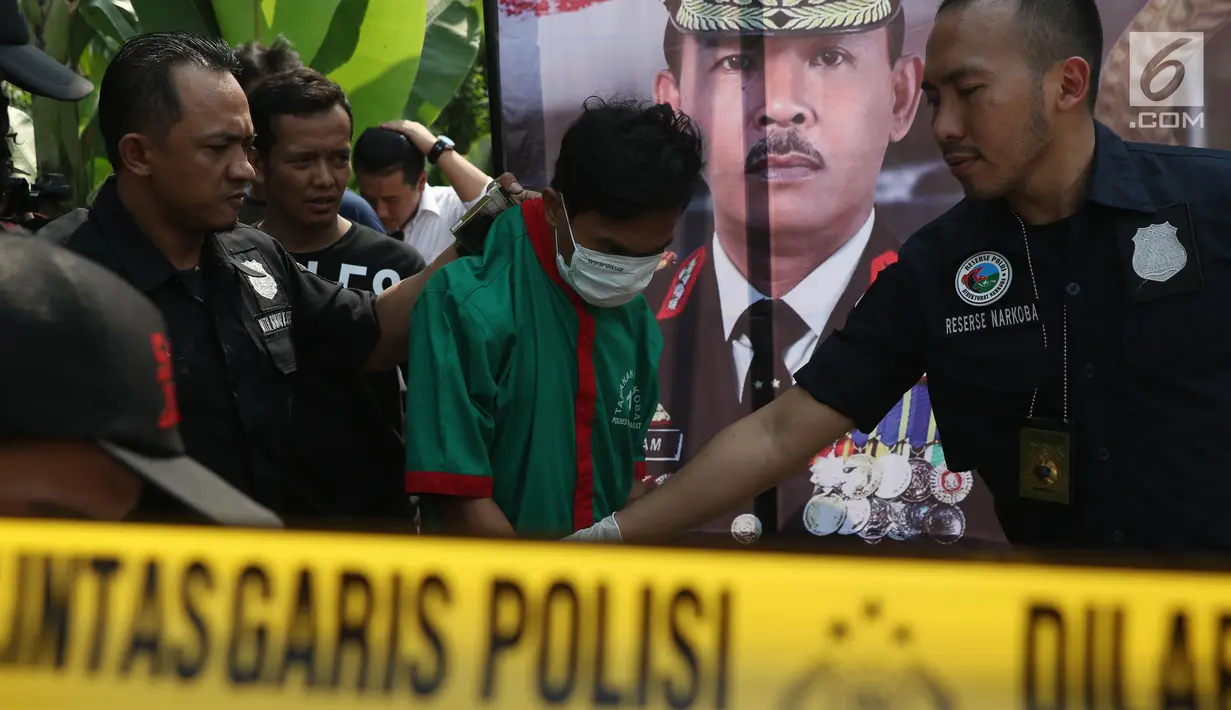 Petugas menggiring salah satu dari tiga tersangka pengedar dan pembuat narkoba di sebuah perumahan di Kawasan Pondok Rajeg, Cibinong, Jawa Barat, Senin (24/9). Polisi juga menahan sejumlah barang bukti terkait. (Liputan6.com/Helmi Fithriansyah)