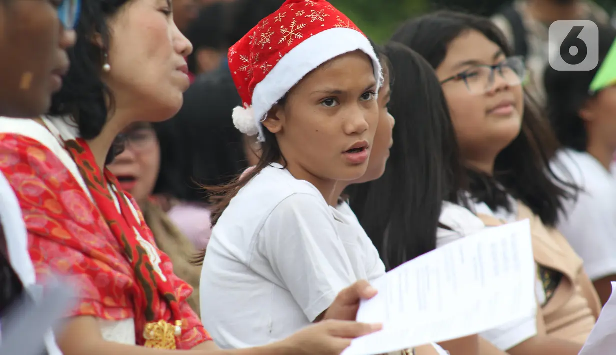Jemaat dari Gereja Kristen Indonesia (GKI) Yasmin Bogor dan HKBP Filadelfia Bekasi melaksanakan misa Natal di Simpang Barat Laut Monas atau depan Istana Negara, Jakarta, Rabu (25/12/2019). Ini adalah misa natal kedelapan yang digelar jemaat dua gereja tersebut. (Liputan6.com/Helmi Fithriansyah)