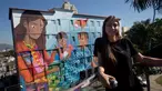 Seniman Brasil, Luna Buschinelli berpose dengan latar belakang mural berjudul 'Contos' di dinding gedung sekolah Rio de Janeiro, (19/6). Karya gadis 19 tahun itu memecahkan rekor dunia sebagai mural terbesar yang dibuat oleh wanita. (AP/Silvia Izquierdo)